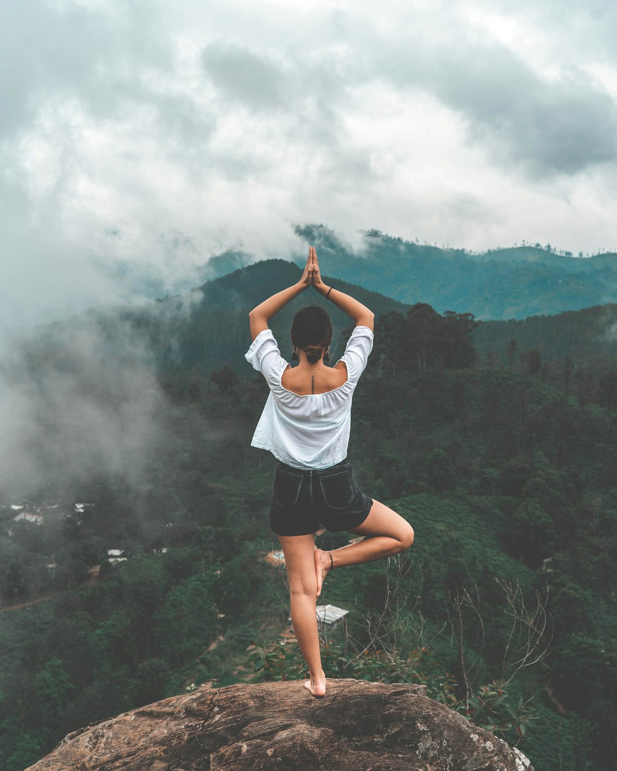A person meditating in a beautiful modern room with large windows showing the sky